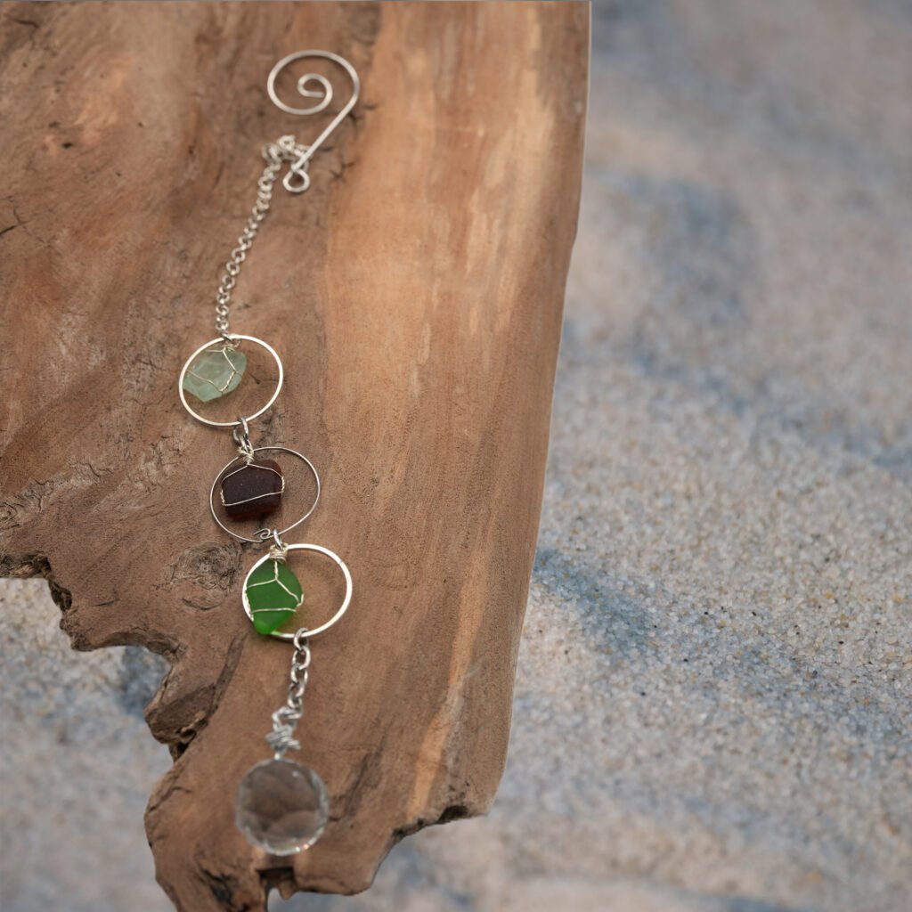 suncatcher on driftwood in the sand